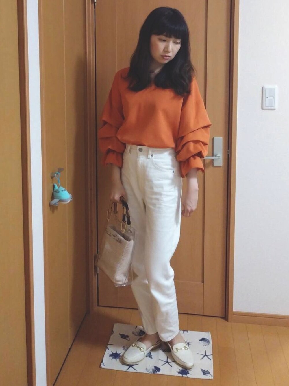 ホワイト系のデニムパンツ、オレンジ系のシャツ/ブラウス、ホワイト系のサンダルを着用したレディースの夏コーディネートの1枚目の写真