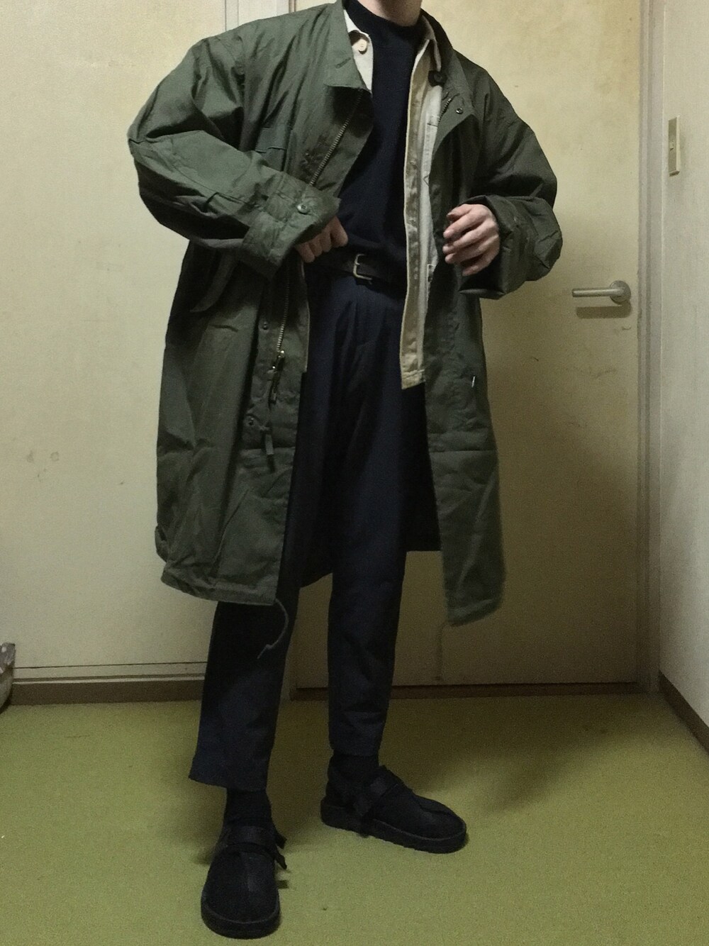 ブラック系のサンダル、グリーン系のダッフルコート、ベージュ系のジャケット/アウターを着用したメンズの冬コーディネートの1枚目の写真