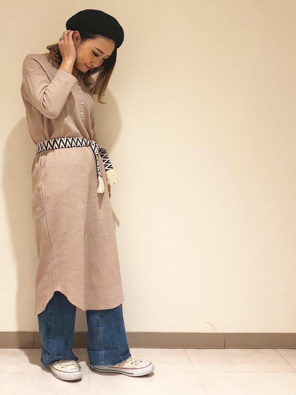 ブラウン系のワンピース、ブルー系のデニムパンツ、ブラック系のベルトを着用したレディースの冬コーディネートの1枚目の写真