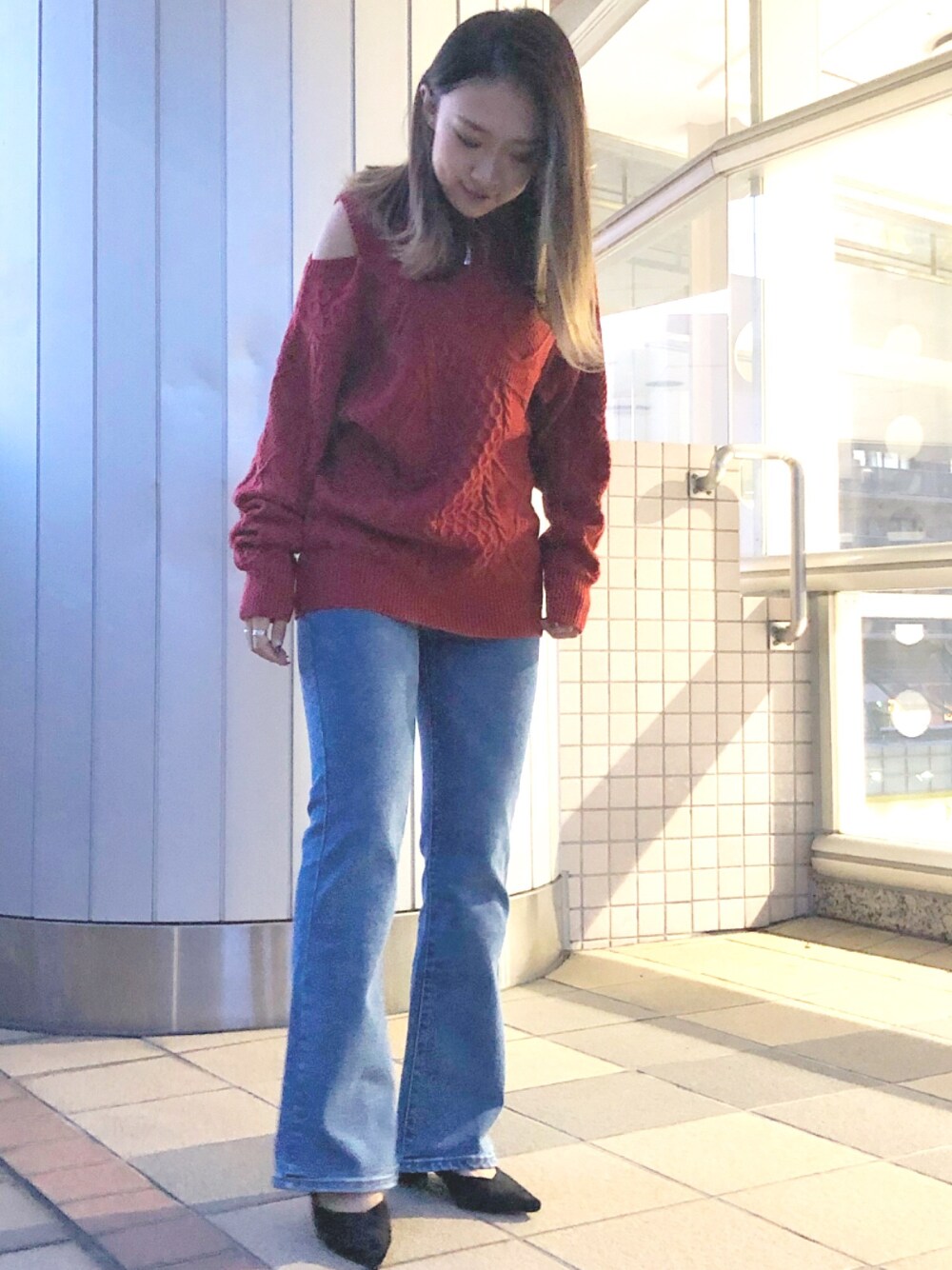 レッド系のニット/セーター、ブラック系のパンプスを着用したレディースの秋コーディネートの1枚目の写真