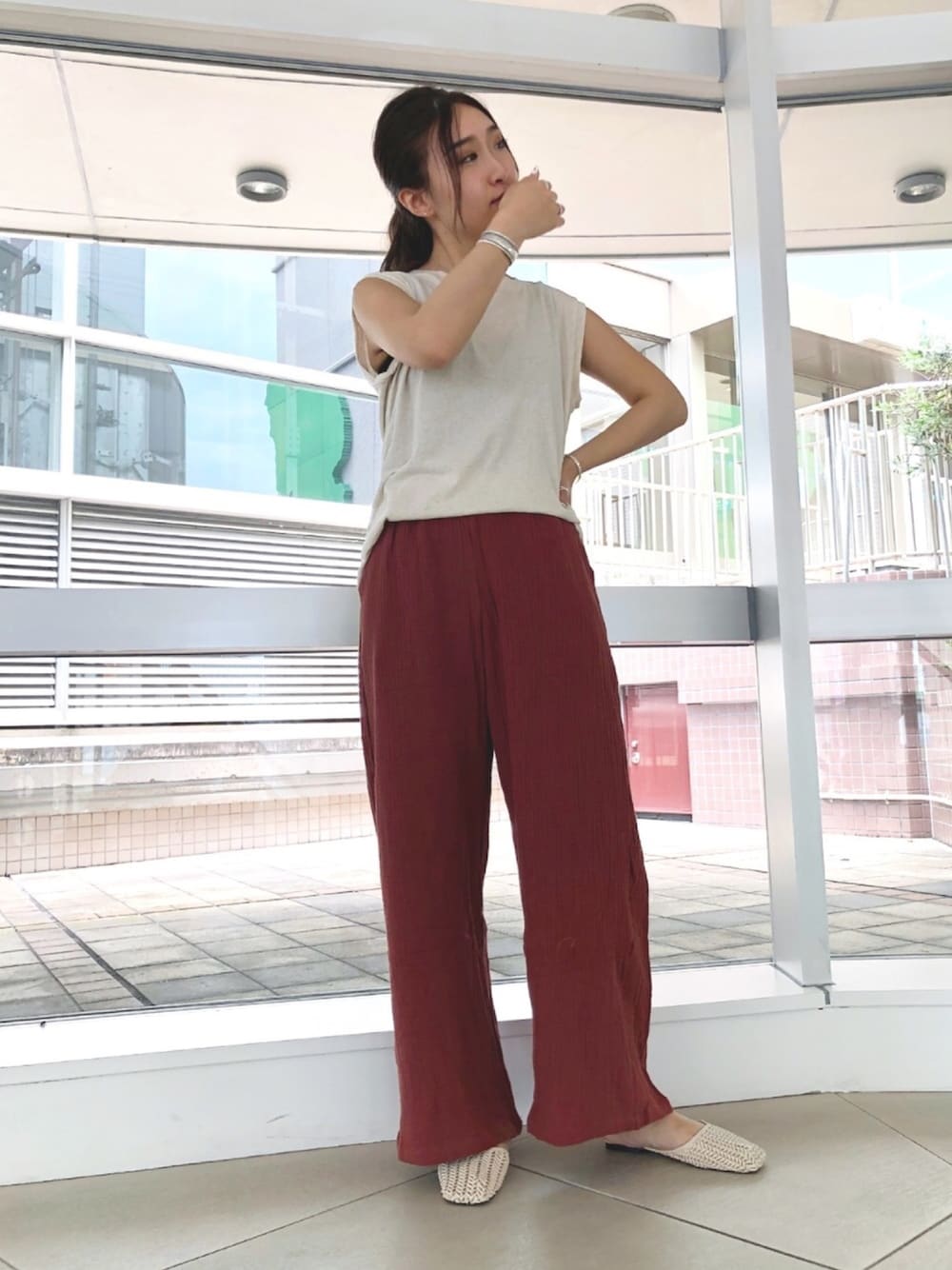 ベージュ系のTシャツ/カットソー、ブラウン系のその他パンツ、ベージュ系のサンダルを着用したレディースの夏コーディネートの1枚目の写真