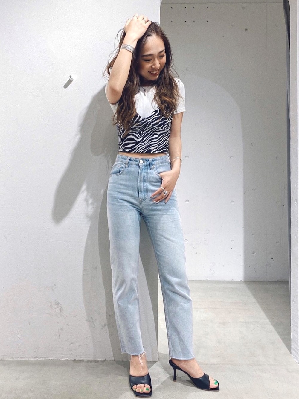 ホワイト系のTシャツ/カットソー、ブラック系のキャミソール、ブルー系のデニムパンツを着用したレディースの夏コーディネートの1枚目の写真