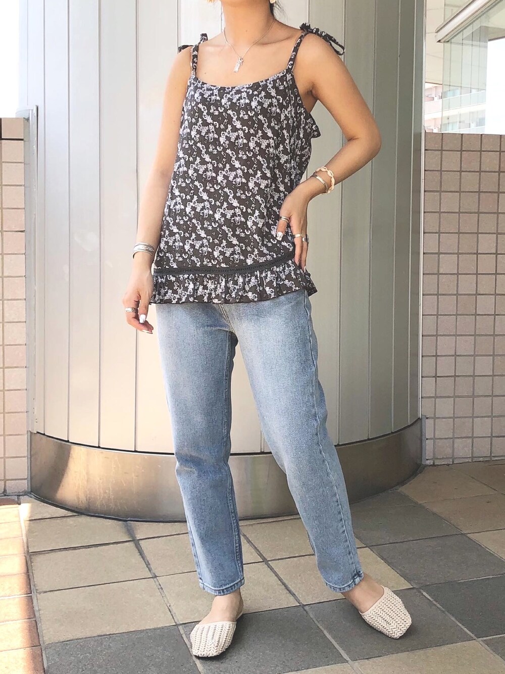 ブラック系のキャミソール、ブルー系のデニムパンツを着用したレディースの夏コーディネートの1枚目の写真