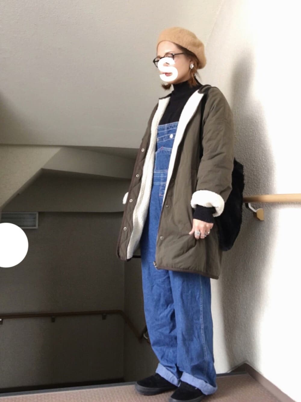 グリーン系のその他アウター、ブラック系のニット/セーター、ブラック系のスニーカーを着用したレディースの冬コーディネートの1枚目の写真