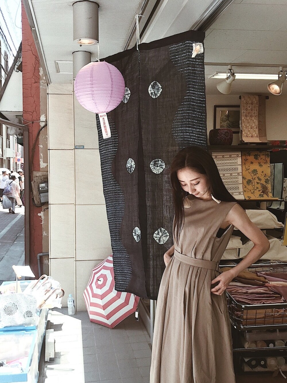 ブラウン系のワンピース、シルバー系のイヤリングを着用したレディースの夏コーディネートの1枚目の写真