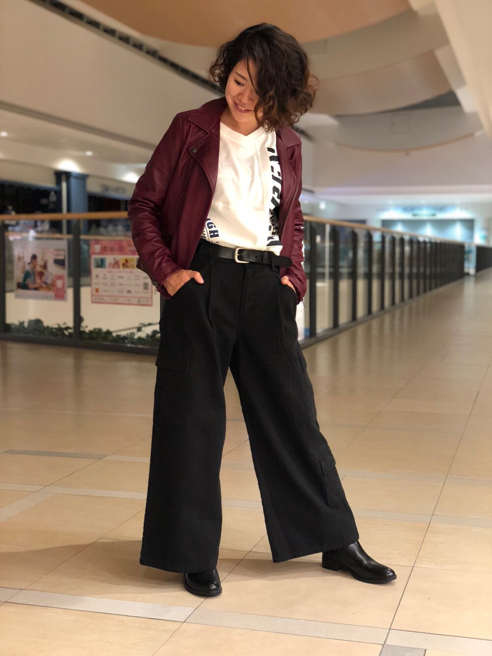 レッド系のライダースジャケット、ホワイト系のTシャツ/カットソー、ブラック系のカーゴパンツを着用したレディースの夏コーディネートの1枚目の写真