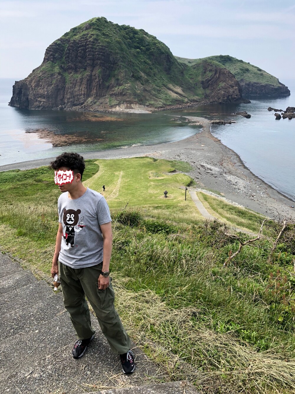 グレー系のTシャツ/カットソー、グリーン系のカーゴパンツ、ブラック系のスニーカーを着用したメンズの春コーディネートの1枚目の写真