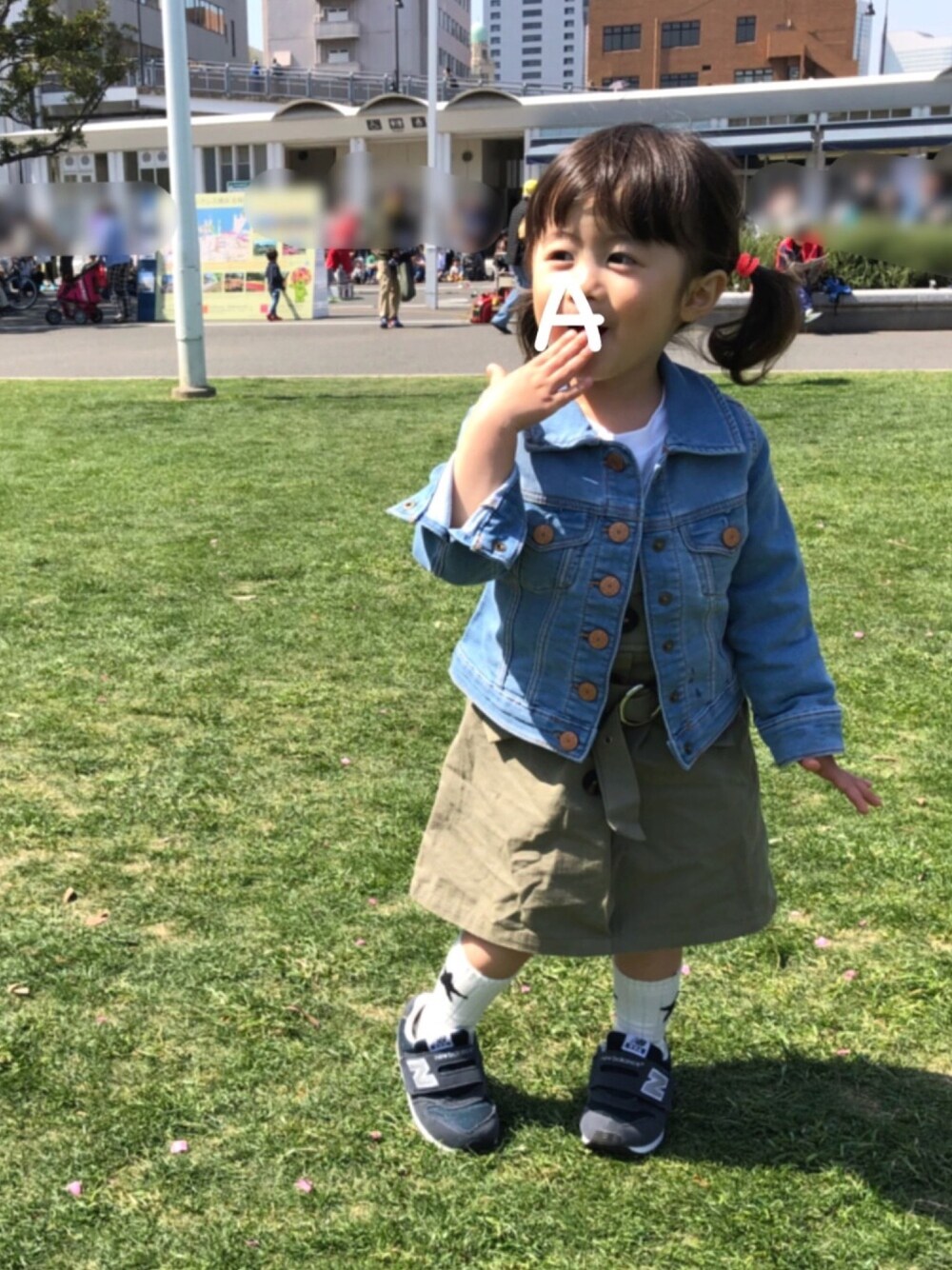 ブルー系のデニムジャケット、グリーン系のワンピース、ブルー系のスニーカーを着用したキッズの春コーディネートの1枚目の写真