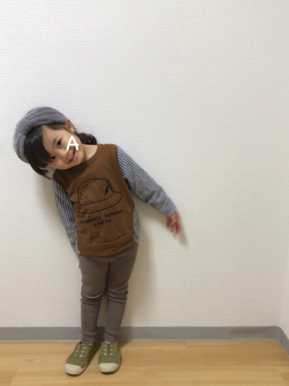 イエロー系のTシャツ/カットソー、グリーン系のスニーカー、グレー系のヘアバンドを着用したキッズの秋コーディネートの1枚目の写真