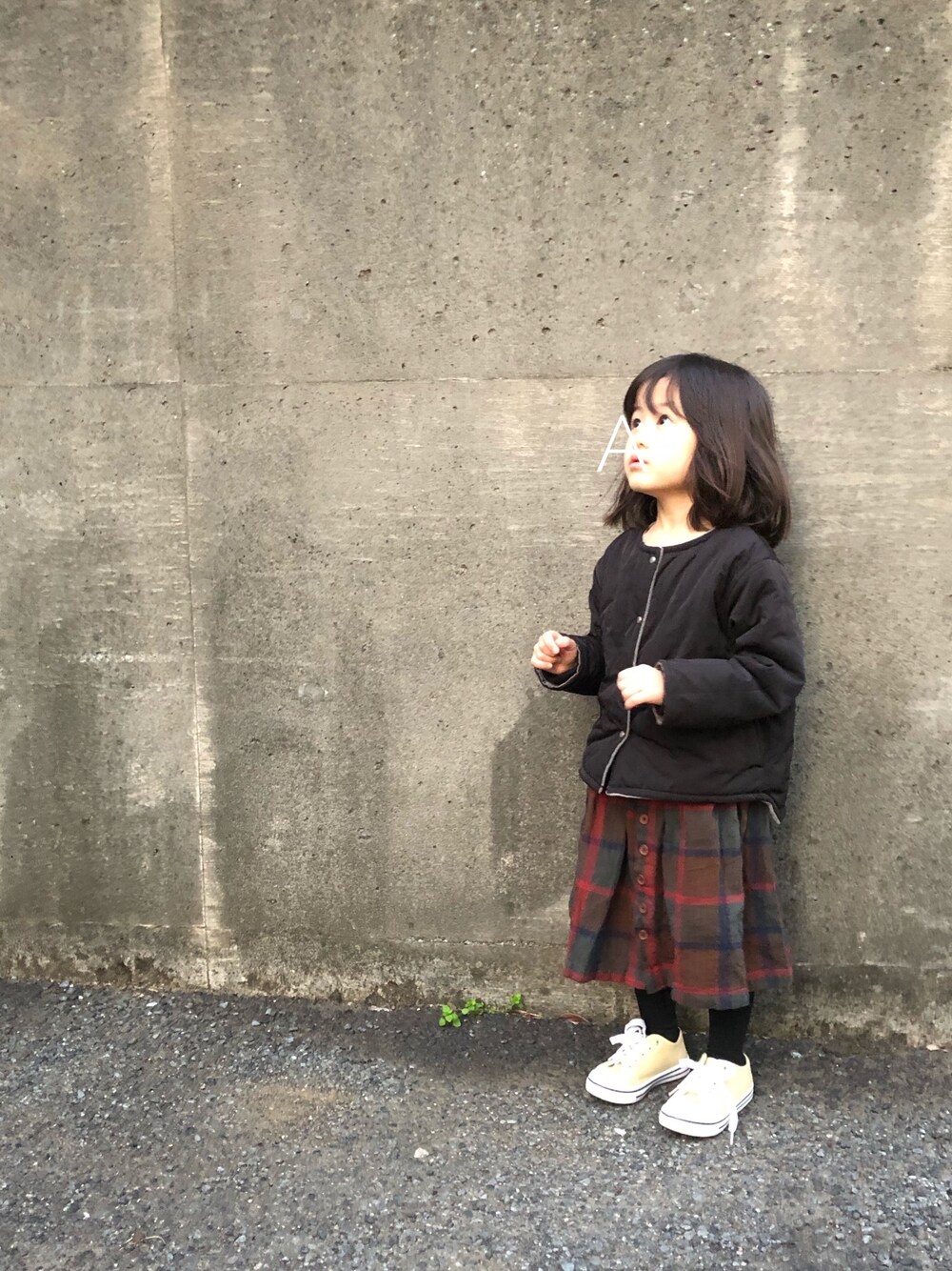 ブラック系のブルゾン、レッド系のスカート、ベージュ系のスニーカーを着用したキッズの冬コーディネートの1枚目の写真