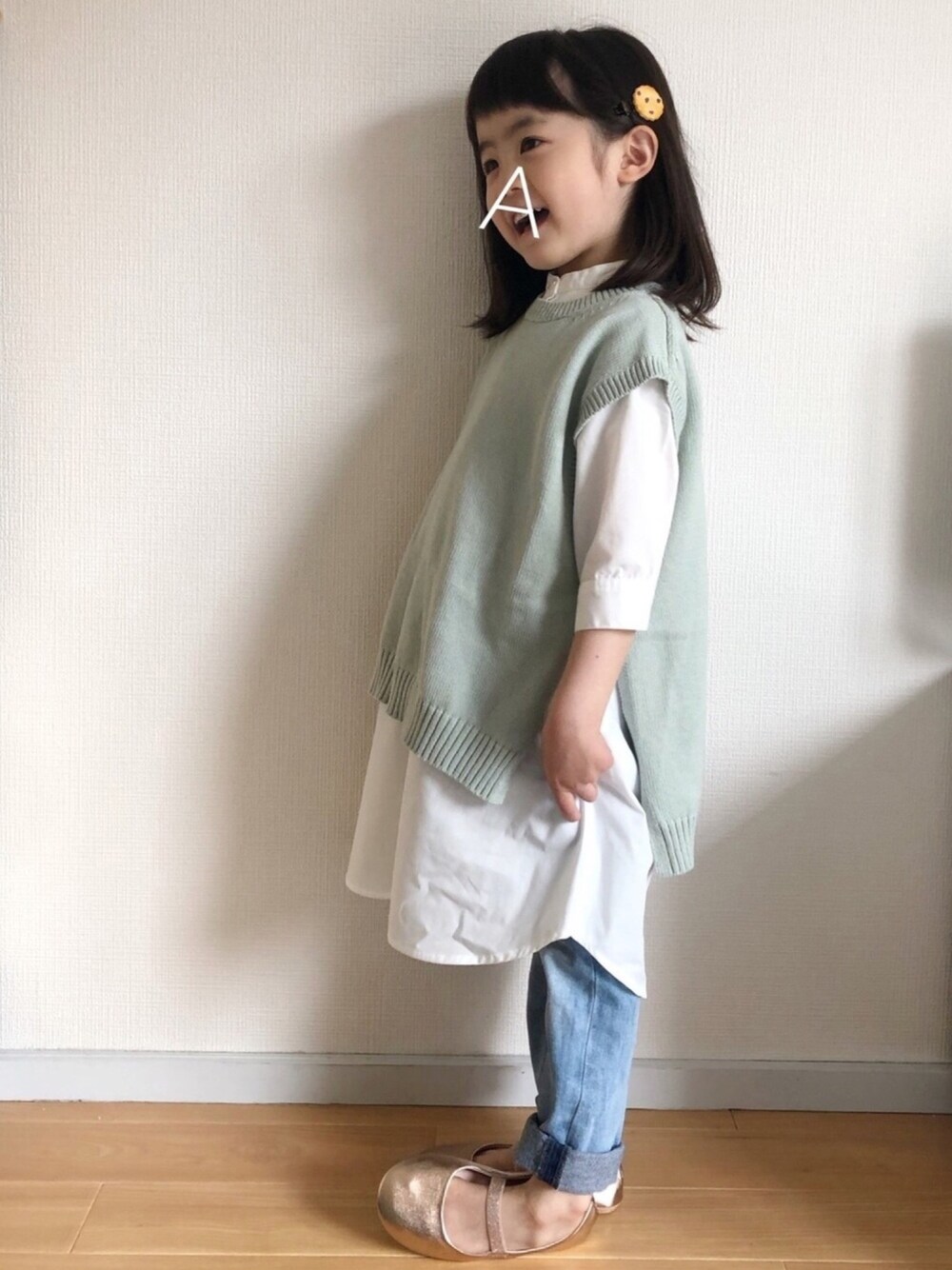 グリーン系のワンピース、ブルー系のデニムパンツ、ゴールド系のバレエシューズを着用したキッズの春コーディネートの1枚目の写真