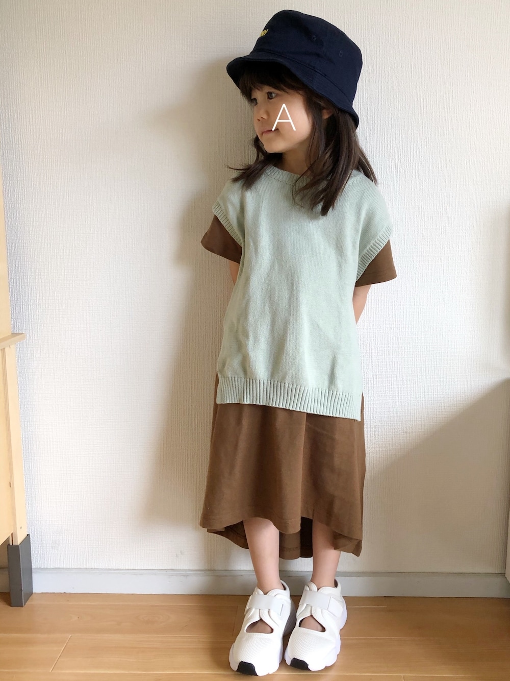 グリーン系のワンピース、イエロー系のワンピース、ホワイト系のシューズを着用したキッズの夏コーディネートの1枚目の写真