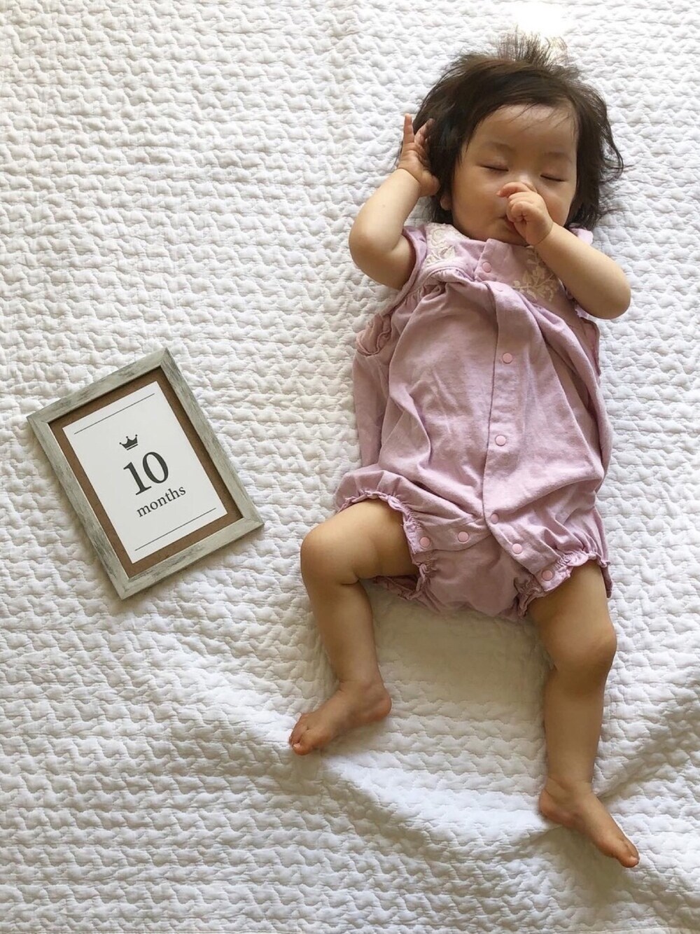 パープル系のロンパース、パープル系のラッピングキットを着用したキッズの夏コーディネートの1枚目の写真