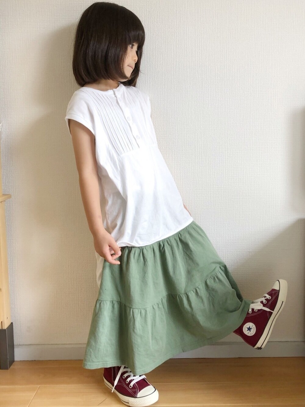 ホワイト系のTシャツ/カットソー、グリーン系のスカート、レッド系のスニーカーを着用したキッズの夏コーディネートの1枚目の写真