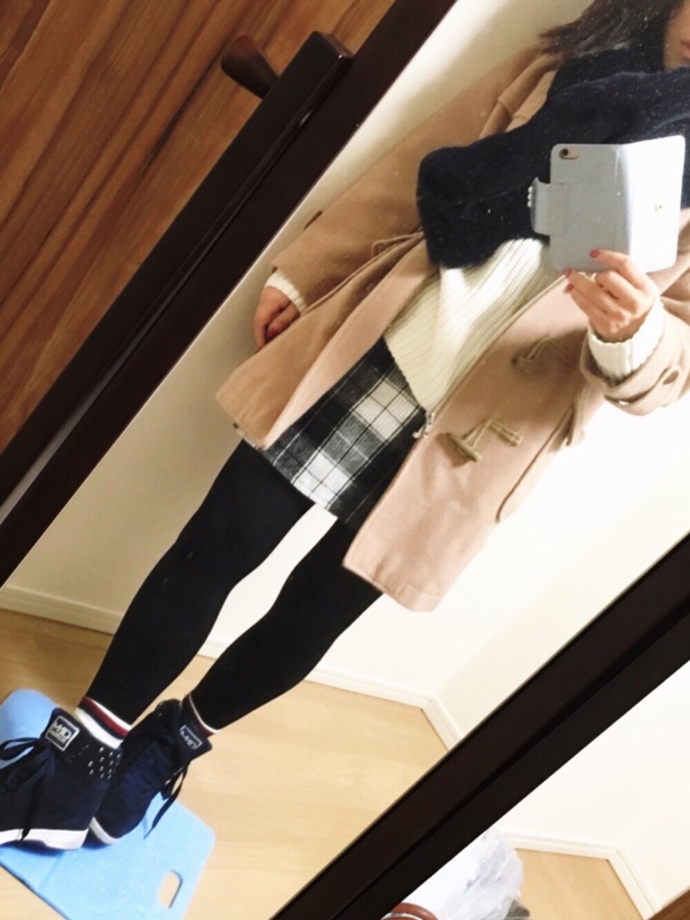 ブラック系のスカート、ベージュ系のダッフルコート、ホワイト系のニット/セーターを着用したレディースの冬コーディネートの1枚目の写真