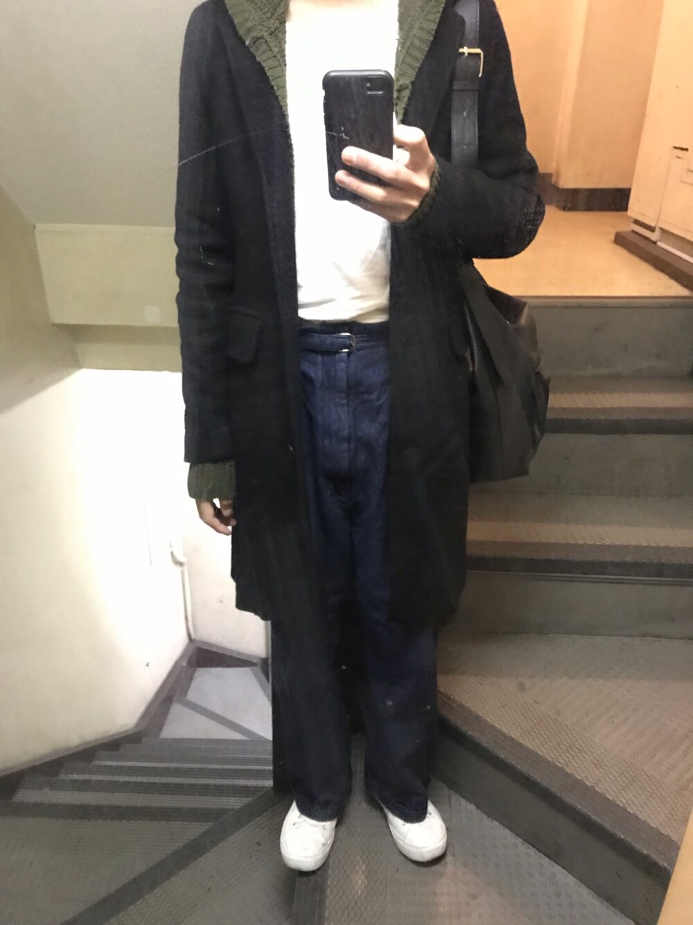 ホワイト系のTシャツ/カットソー、ブルー系のデニムパンツ、グリーン系のニット/セーターを着用したメンズの冬コーディネートの1枚目の写真