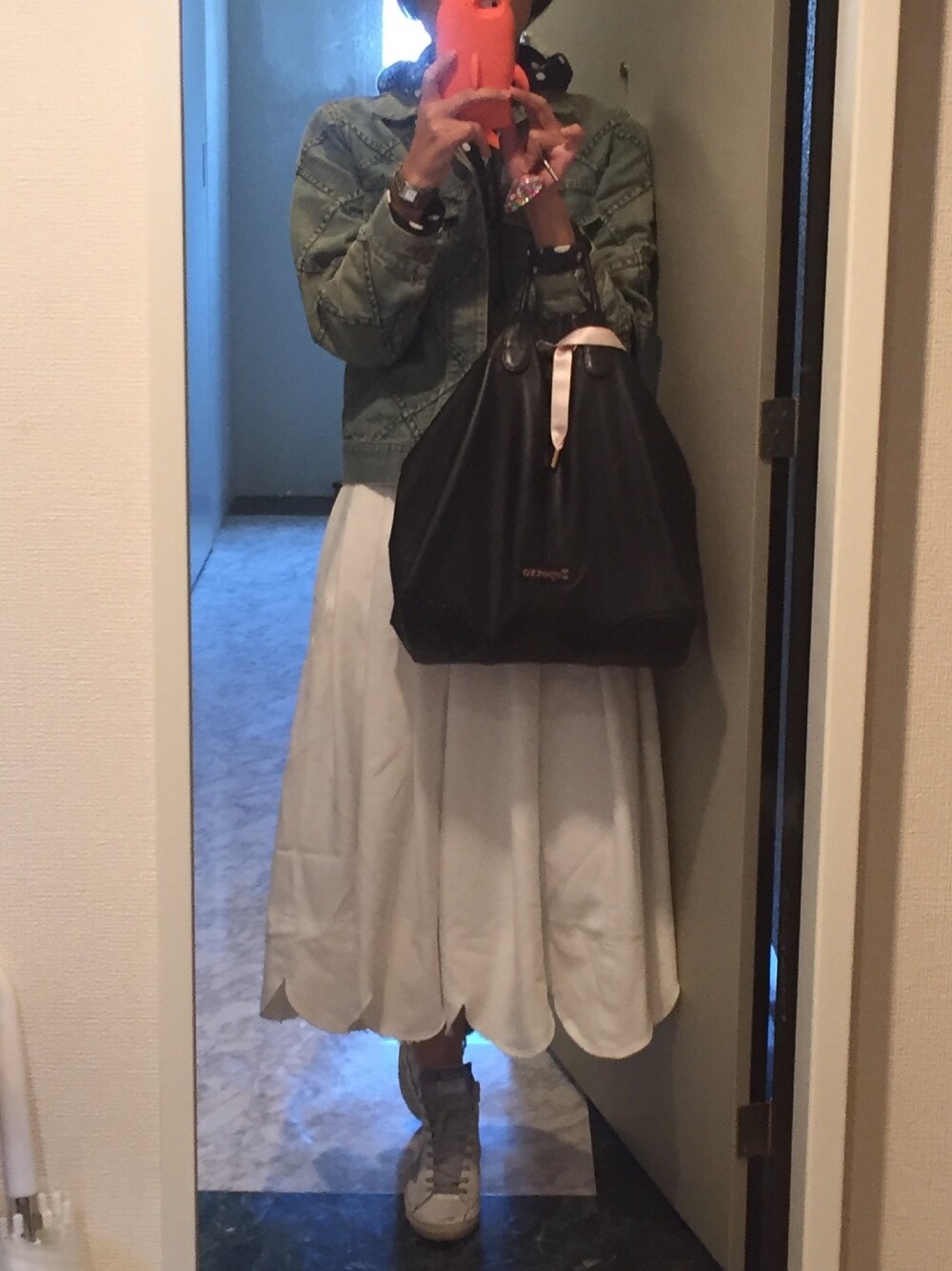 ブラック系のトートバッグ、ホワイト系のスカート、ホワイト系のスニーカーを着用したレディースの春コーディネートの1枚目の写真