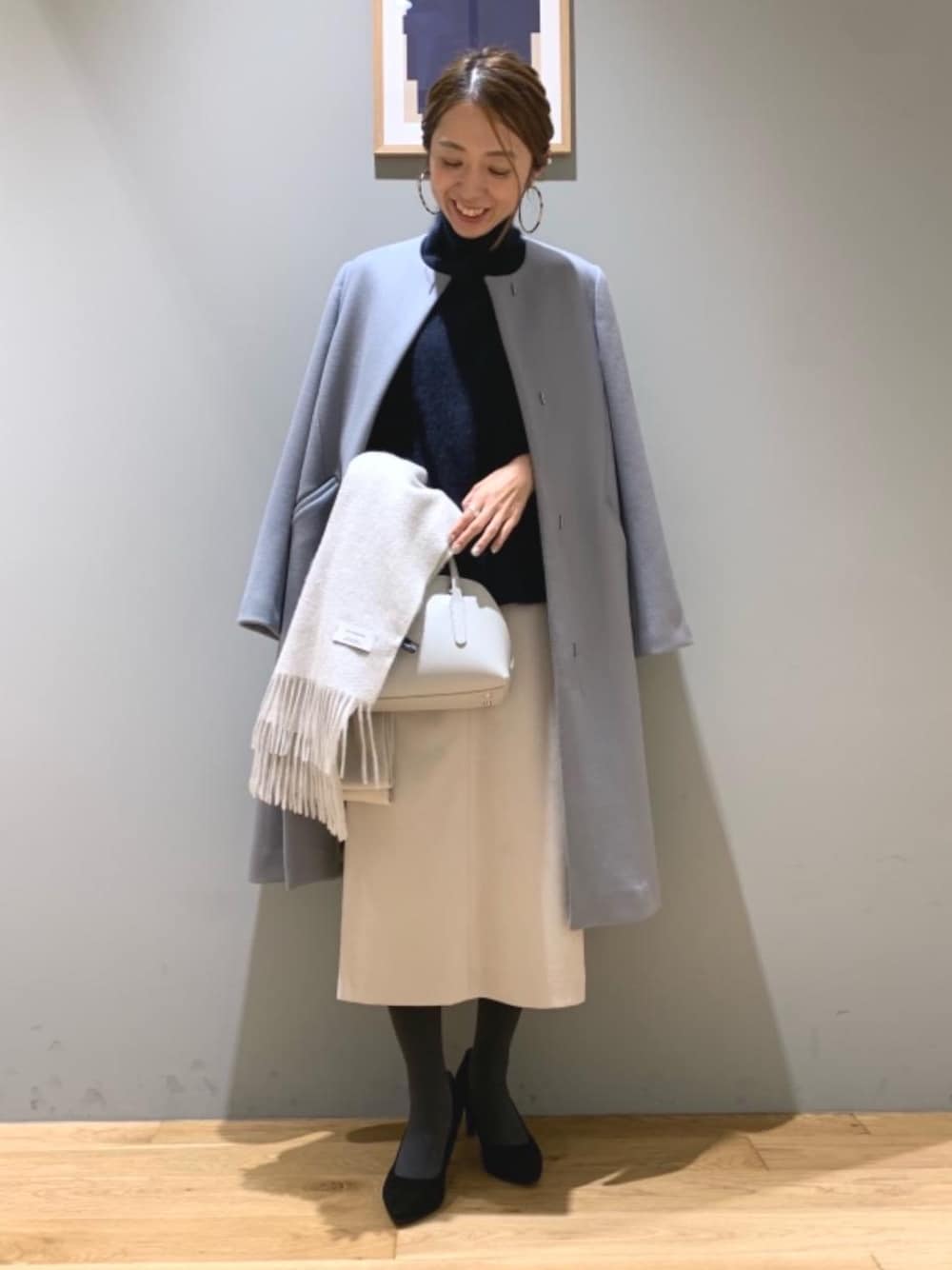 ブルー系のニット/セーター、グレー系のショルダーバッグ、グリーン系のノーカラーコートを着用したレディースの秋コーディネートの1枚目の写真