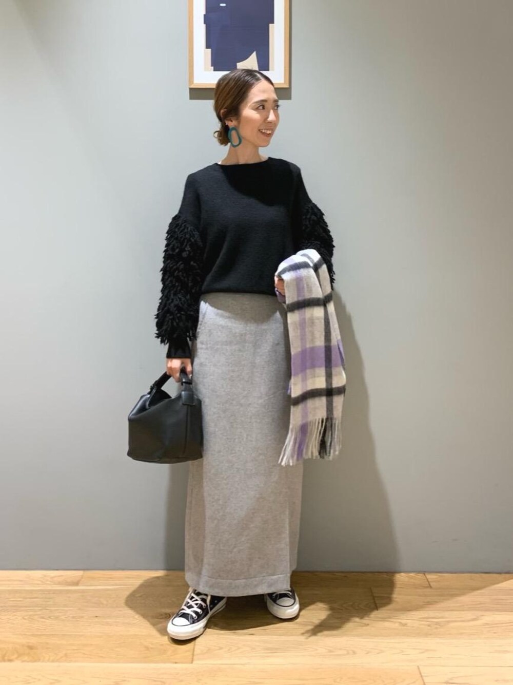 ブラック系のスニーカー、グレー系のスカート、ブラック系のショルダーバッグを着用したレディースの冬コーディネートの1枚目の写真