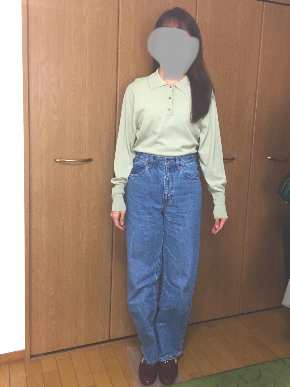 グリーン系のニット/セーター、ブルー系のデニムパンツ、レッド系のローファーを着用したレディースの春コーディネートの1枚目の写真