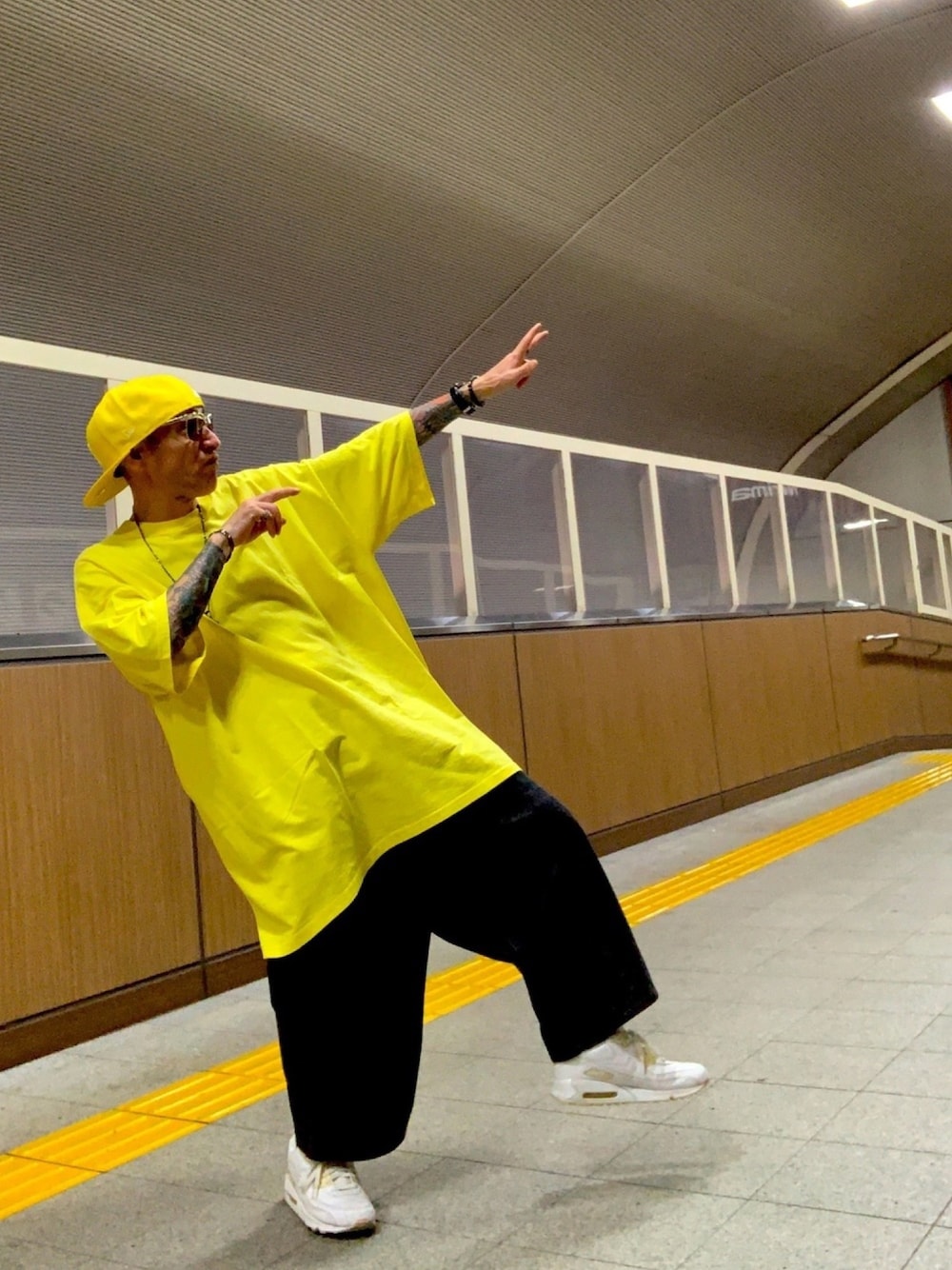 イエロー系のTシャツ/カットソー、ブラック系のデニムパンツ、ホワイト系のスニーカーを着用したメンズの夏コーディネートの1枚目の写真