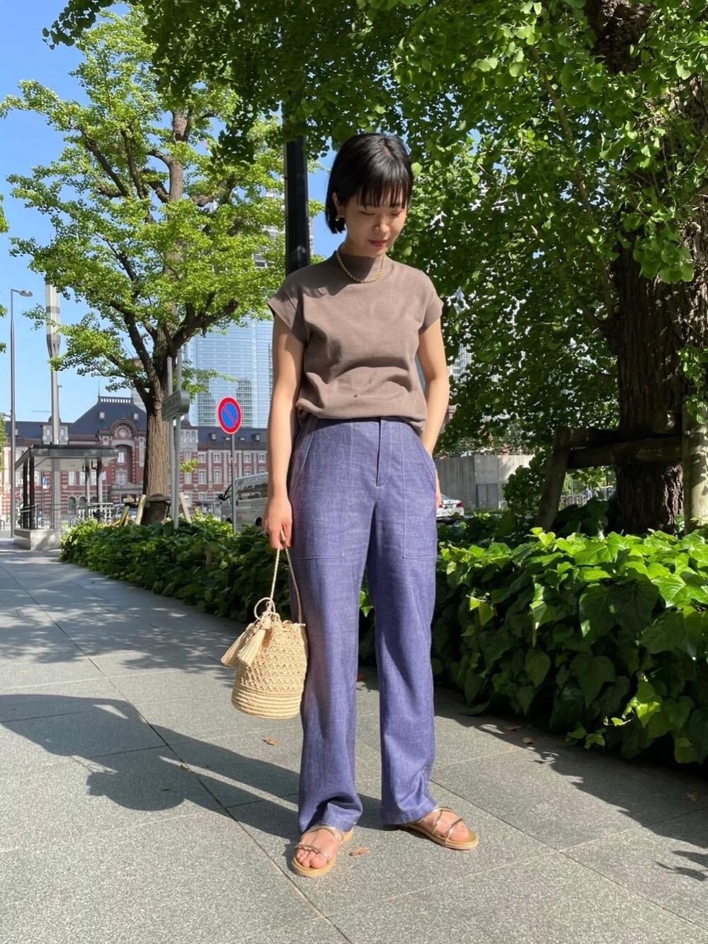 ブルー系のその他パンツ、ゴールド系のサンダル、ホワイト系のショルダーバッグを着用したレディースの春コーディネートの1枚目の写真