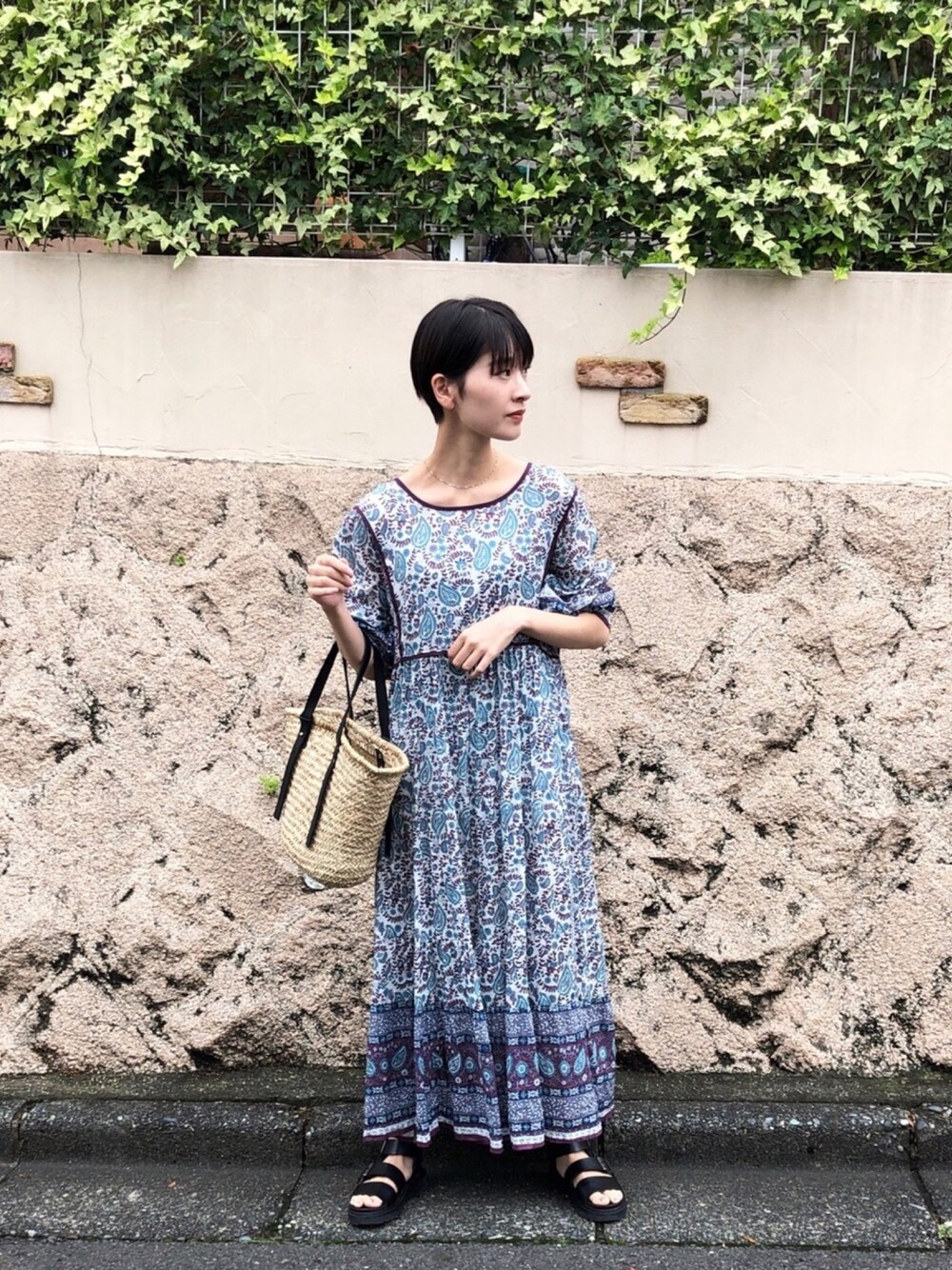 ブルー系のワンピース/ドレス、ブラック系のかごバッグ、シルバー系のネックレスを着用したレディースの夏コーディネートの1枚目の写真