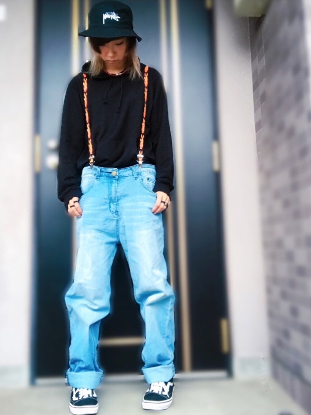 ブラック系のパーカー、ブルー系のデニムパンツ、ブラック系のスニーカーを着用したレディースの秋コーディネートの1枚目の写真