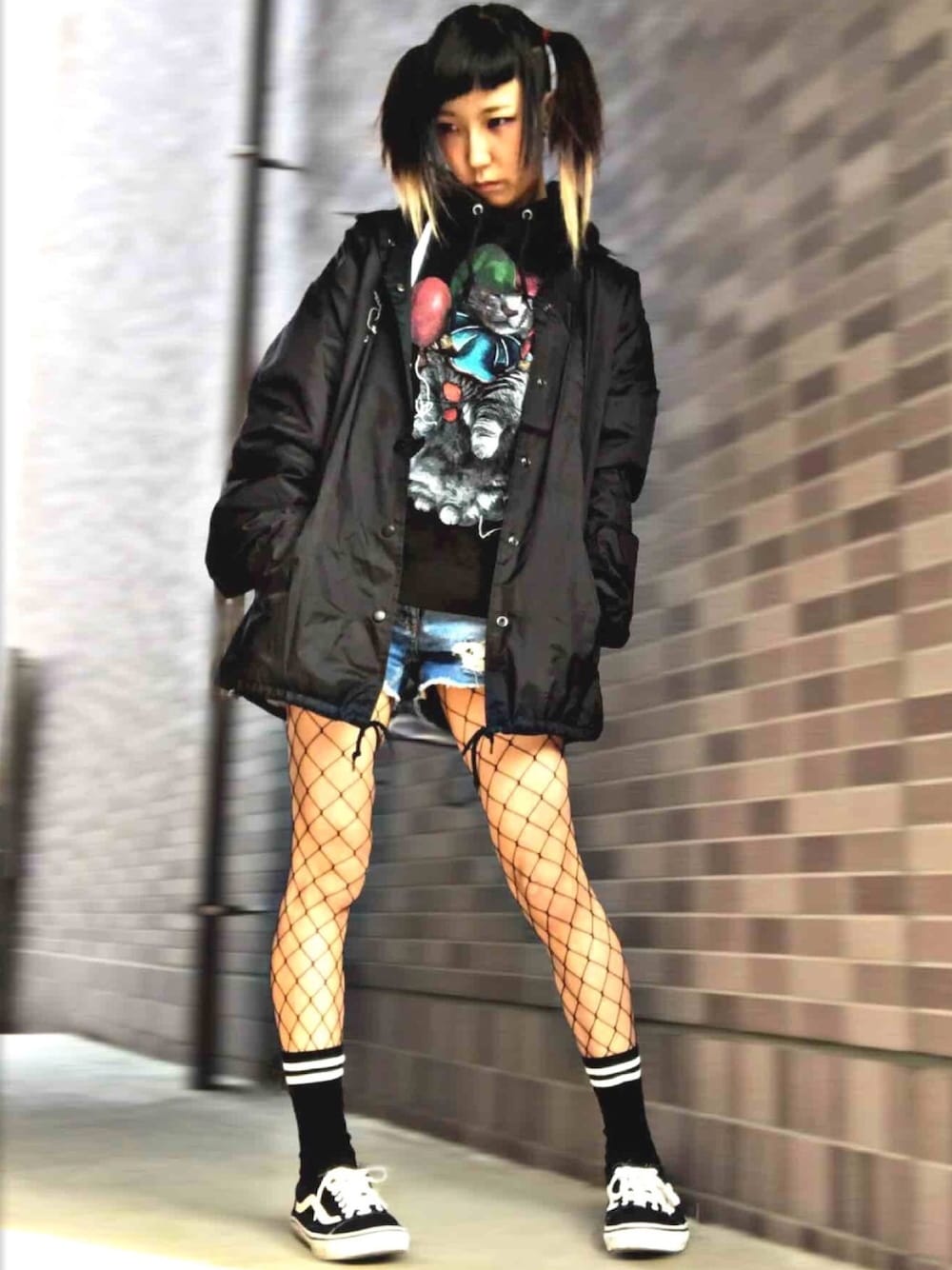 ブラック系のパーカー、ブラック系のナイロンジャケット、ブルー系のデニムパンツを着用したレディースの春コーディネートの1枚目の写真