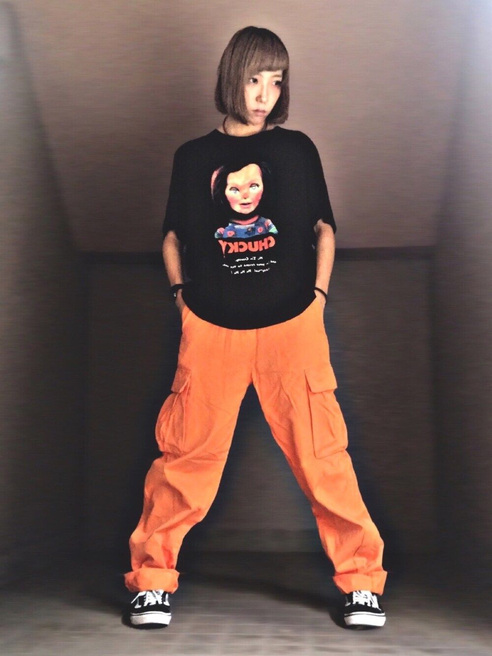 ブラック系のTシャツ/カットソー、オレンジ系のカーゴパンツ、ブラック系のスニーカーを着用したレディースの秋コーディネートの1枚目の写真