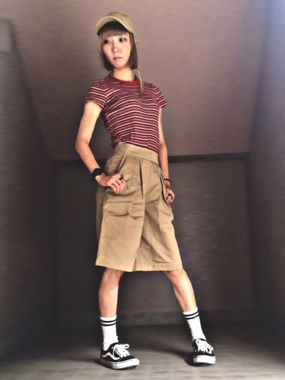 オレンジ系のTシャツ/カットソー、ベージュ系のその他パンツ、ブラック系のスニーカーを着用したレディースの秋コーディネートの1枚目の写真
