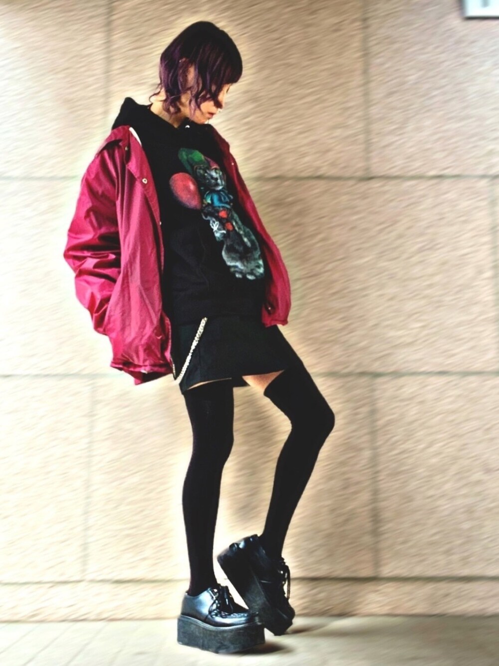 ブラック系のパーカー、レッド系のナイロンジャケット、ブラック系のパンツを着用したレディースの冬コーディネートの1枚目の写真