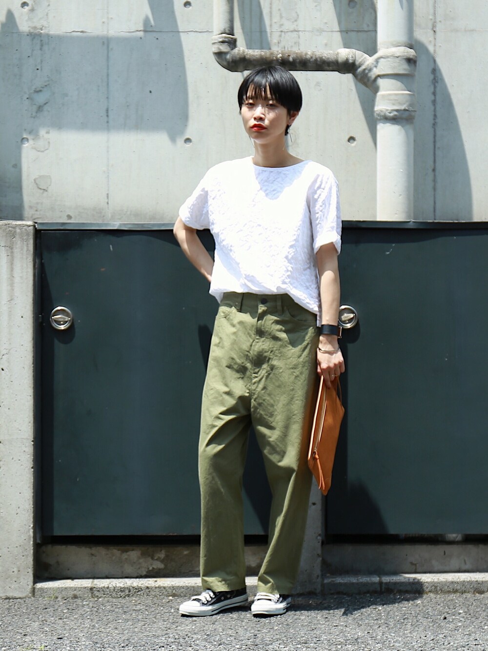 ホワイト系のシャツ/ブラウス、グリーン系のチノパンツ、ブラウン系のクラッチバッグを着用したレディースの春コーディネートの1枚目の写真