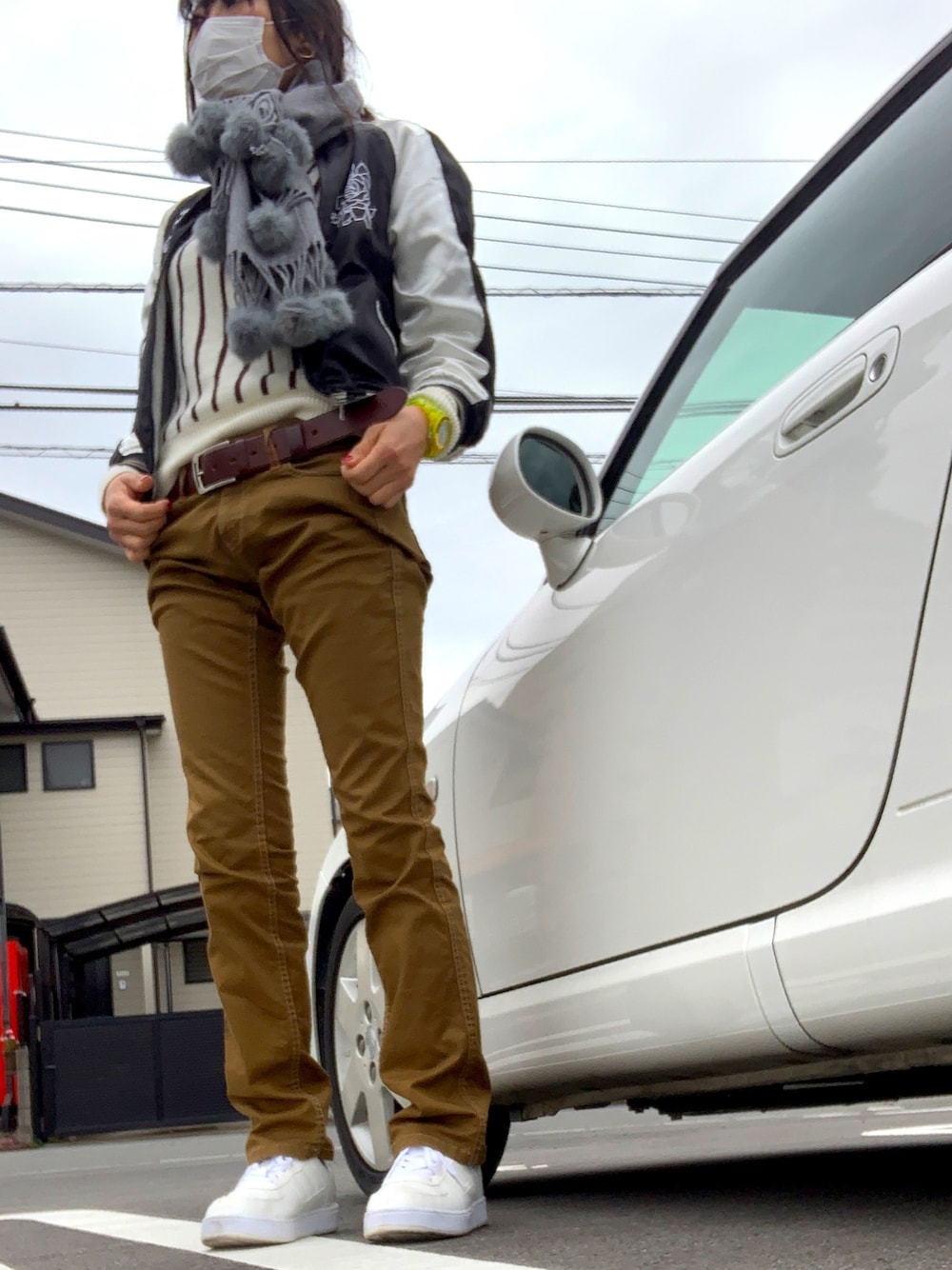 ブラック系のスカジャン、ホワイト系のスニーカー、イエロー系のアナログ腕時計を着用したレディースの冬コーディネートの1枚目の写真