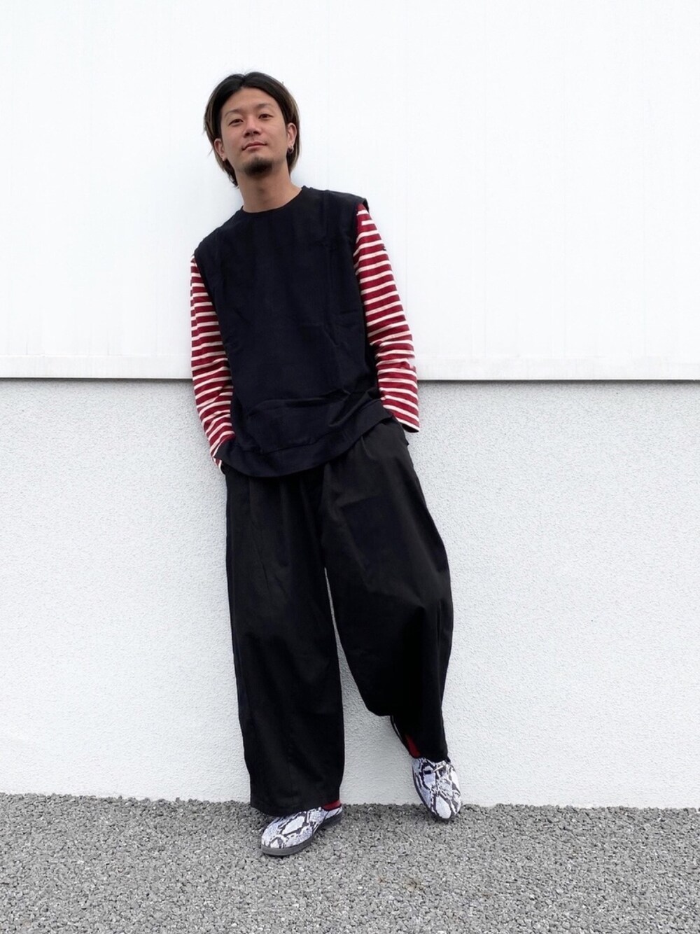 ブラック系のベスト、レッド系のTシャツ/カットソー、ブラック系のその他パンツを着用したメンズの春コーディネートの1枚目の写真