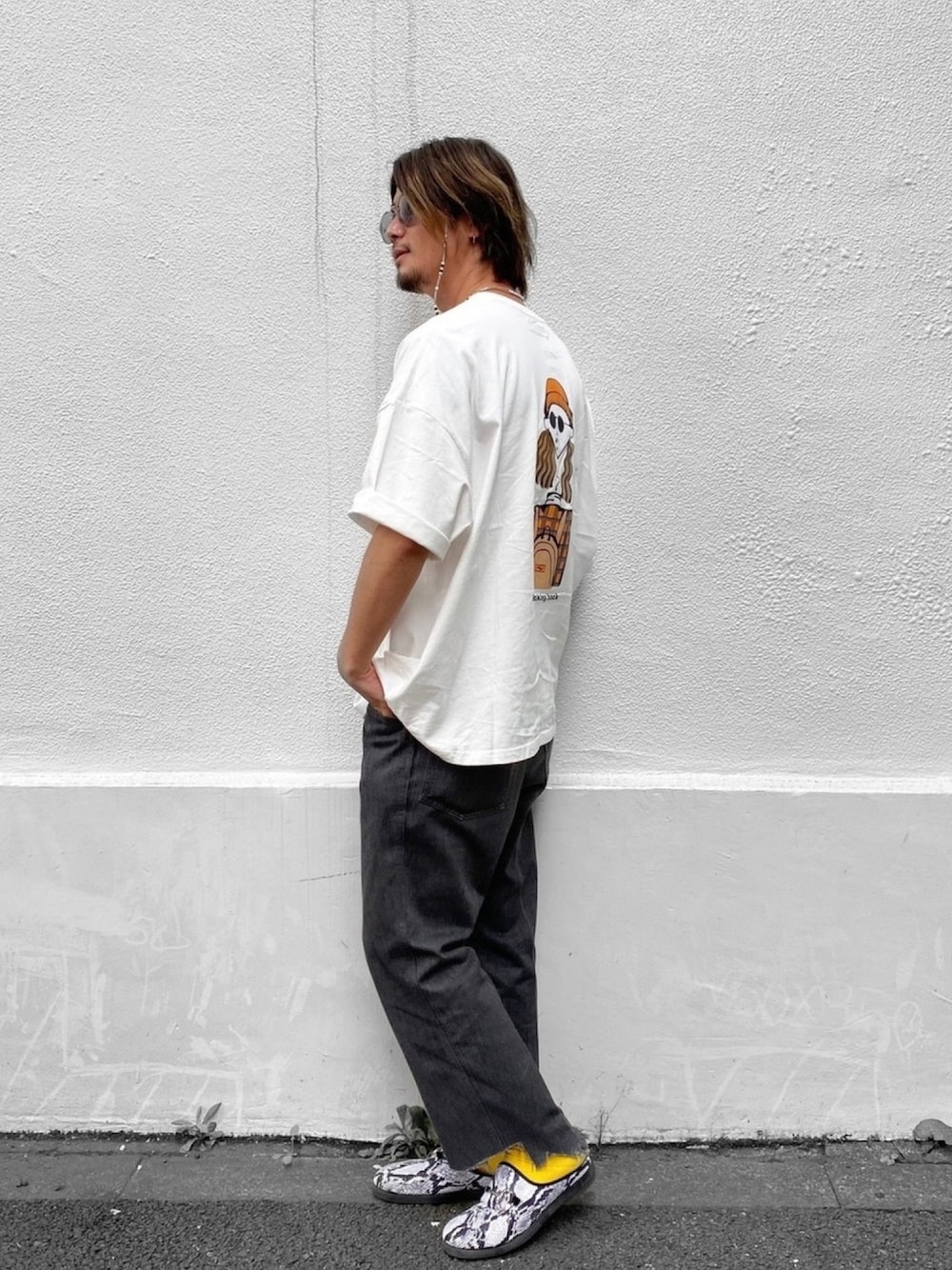 ホワイト系のTシャツ/カットソー、ブラック系のデニムパンツ、ホワイト系のスリッポンを着用したメンズの夏コーディネートの1枚目の写真