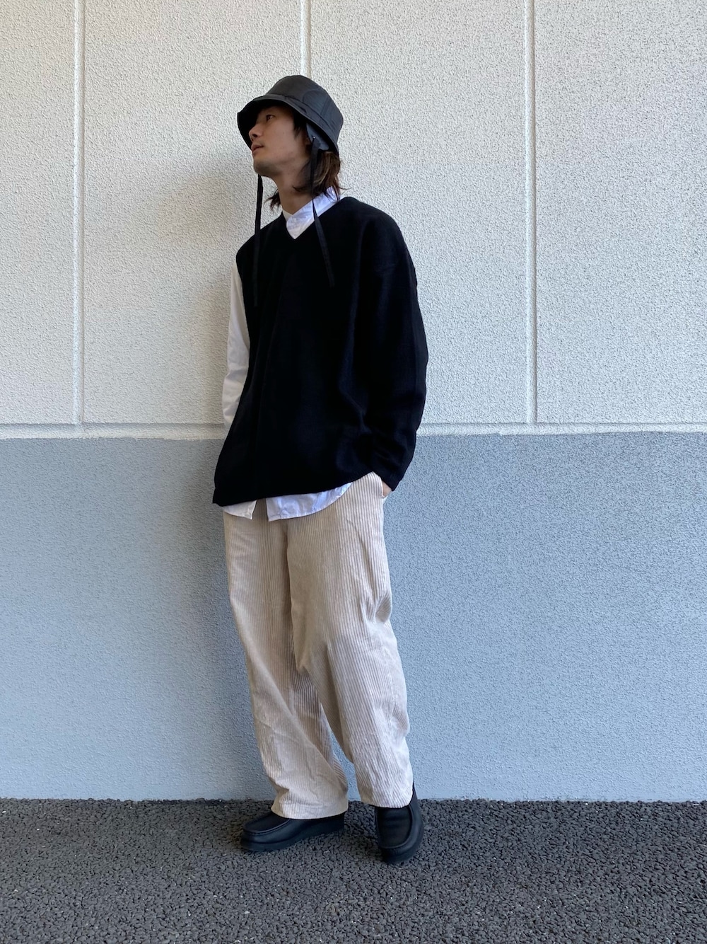 ブラック系のニット/セーター、ブラック系のモカシン/デッキシューズを着用したメンズの冬コーディネートの1枚目の写真