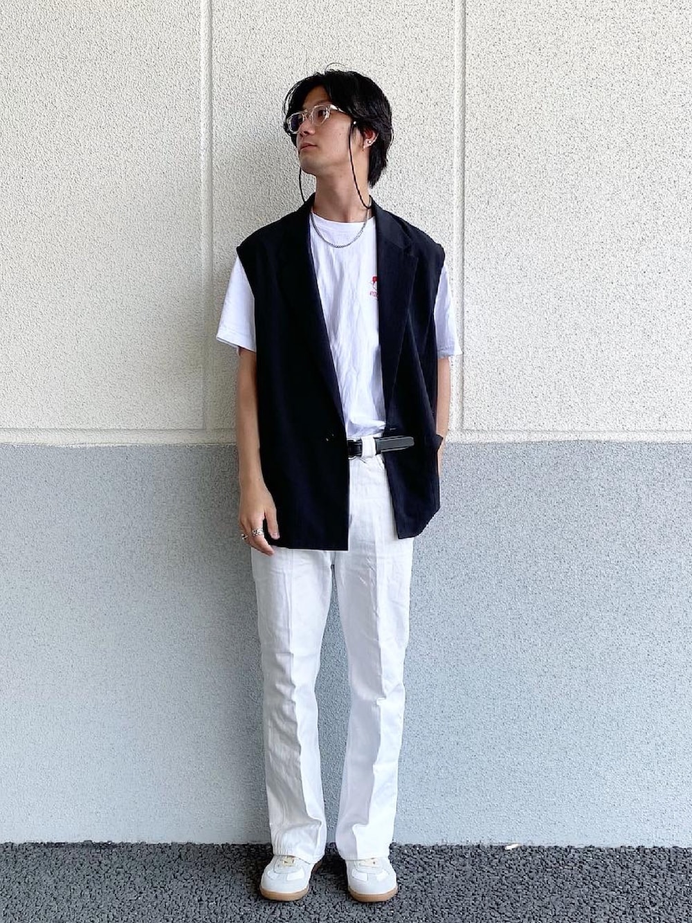 ブラック系のベスト、ホワイト系のデニムパンツ、ホワイト系のスニーカーを着用したメンズの春コーディネートの1枚目の写真