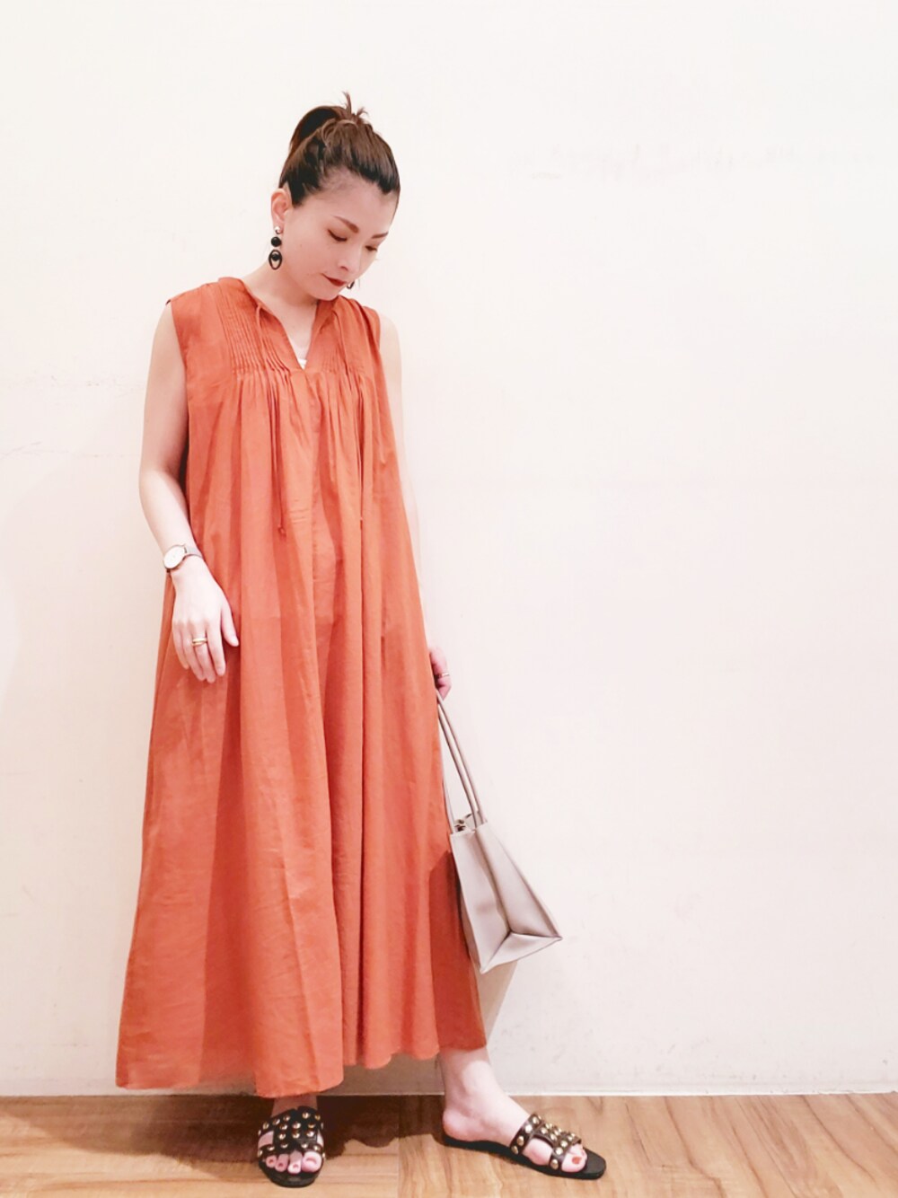 オレンジ系のワンピース、グレー系のトートバッグを着用したレディースの夏コーディネートの1枚目の写真
