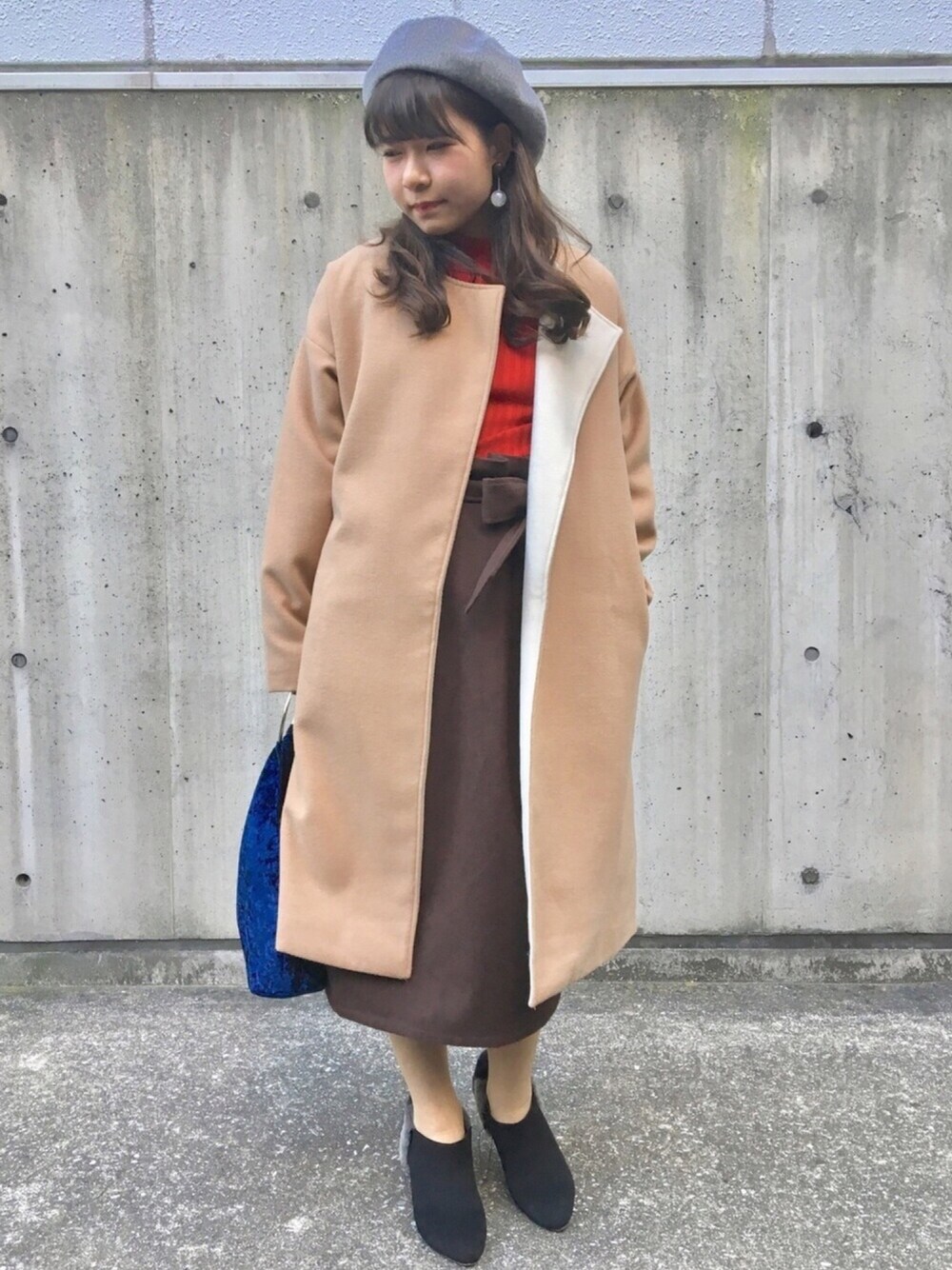 ベージュ系のジャケット/アウター、ブラウン系のスカート、レッド系のニット/セーターを着用したレディースの冬コーディネートの1枚目の写真