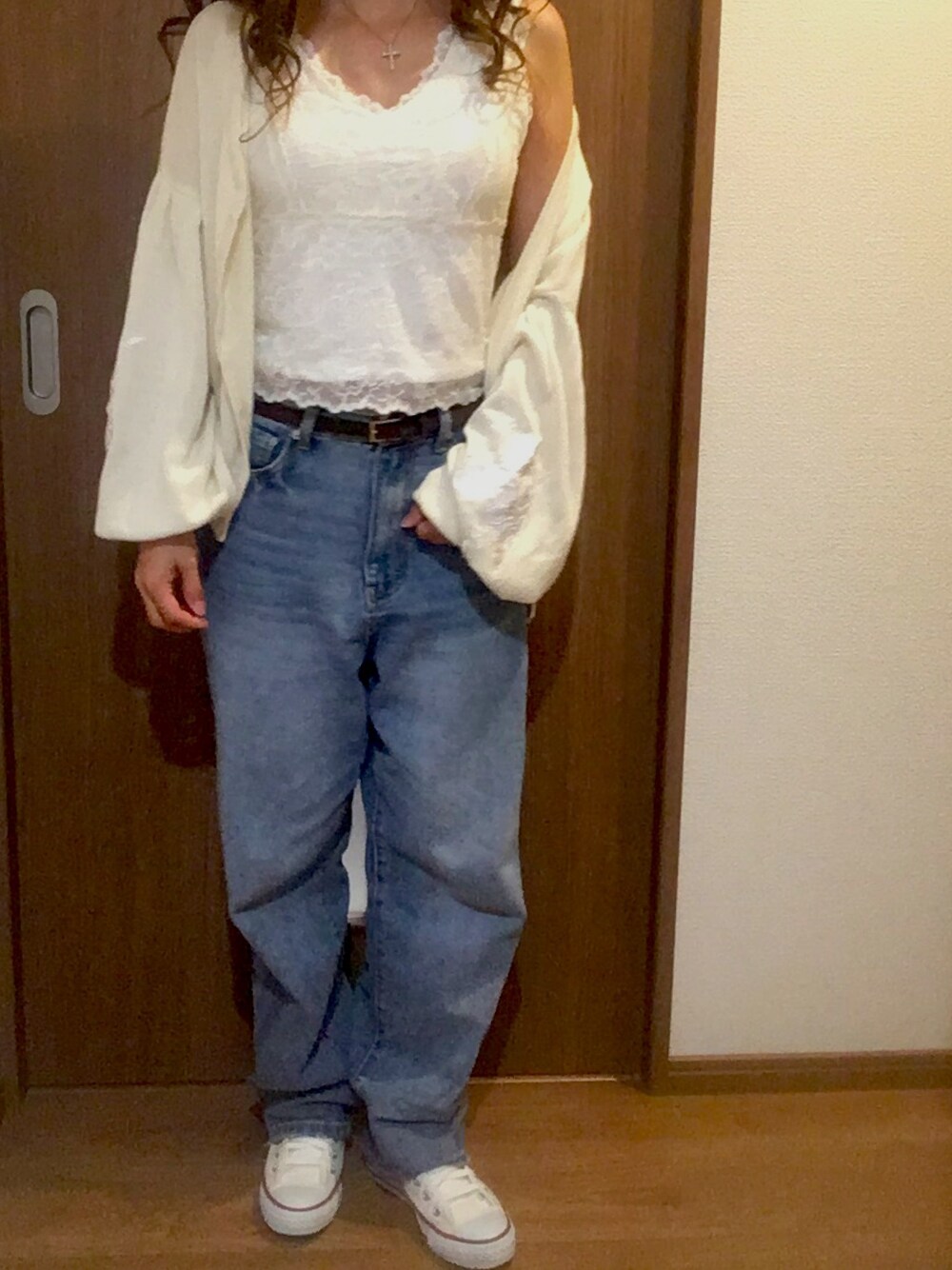 ブルー系のデニムパンツ、ホワイト系のスニーカー、その他のパンツを着用したレディースの秋コーディネートの1枚目の写真