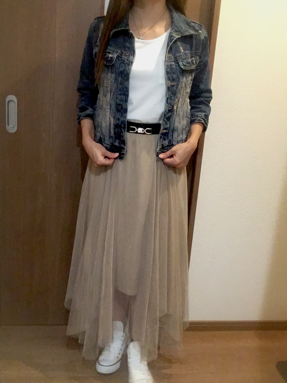 ベージュ系のスカート、ホワイト系のスニーカー、ホワイト系のトップスを着用したレディースの秋コーディネートの1枚目の写真