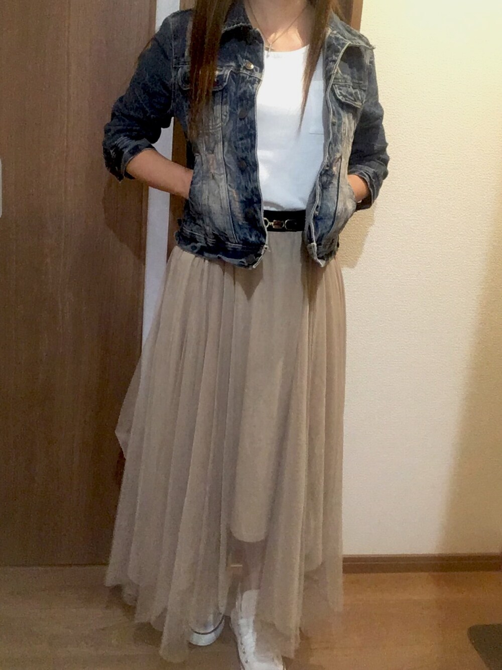 ベージュ系のスカート、ホワイト系のスニーカー、ホワイト系のトップスを着用したレディースの秋コーディネートの1枚目の写真