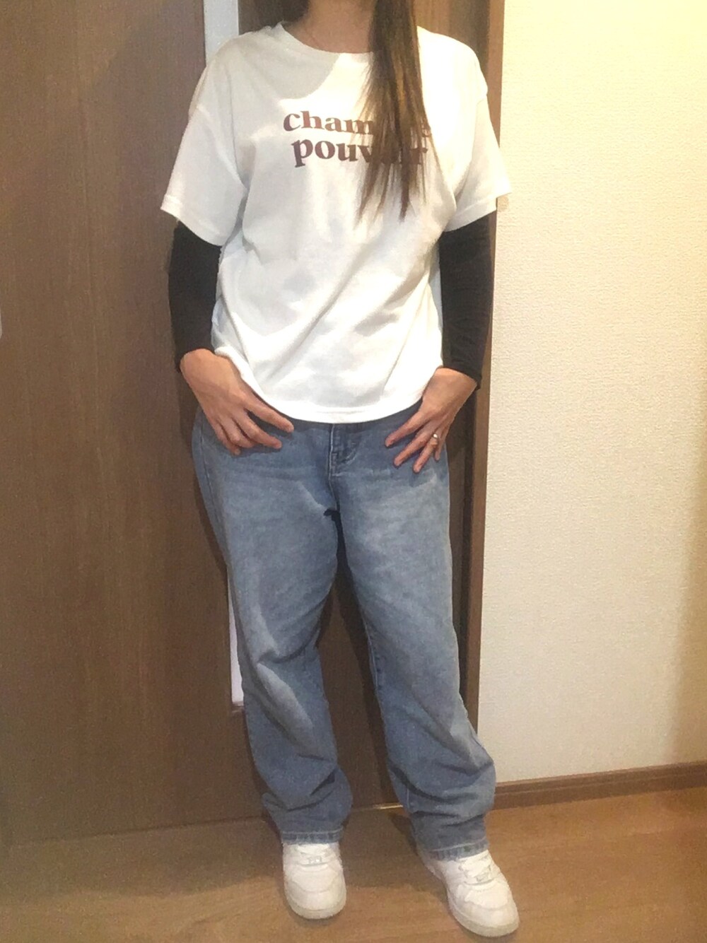 ブルー系のデニムパンツ、ホワイト系のスニーカー、ホワイト系のTシャツ/カットソーを着用したレディースの秋コーディネートの1枚目の写真