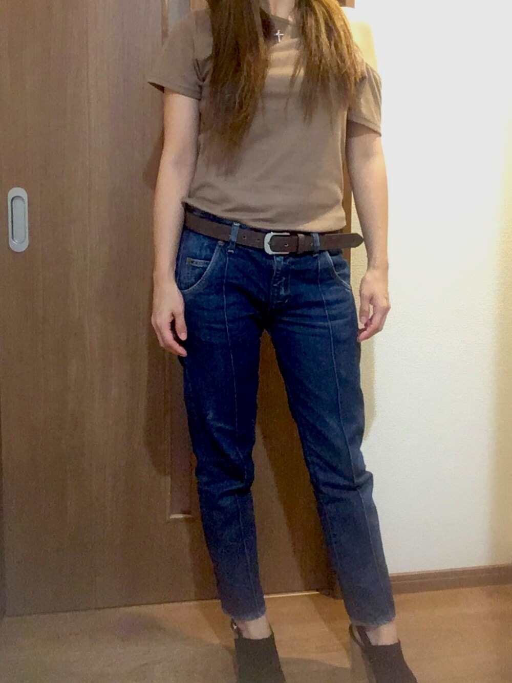 ブルー系のデニムパンツ、ブラウン系のトップスを着用したレディースの秋コーディネートの1枚目の写真