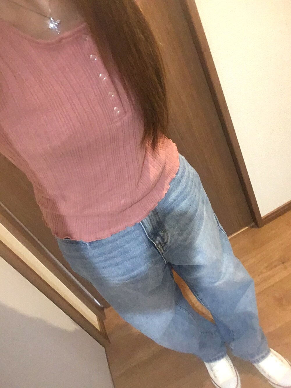 ブルー系のデニムパンツ、ピンク系のタンクトップ、ホワイト系のスニーカーを着用したレディースの秋コーディネートの1枚目の写真