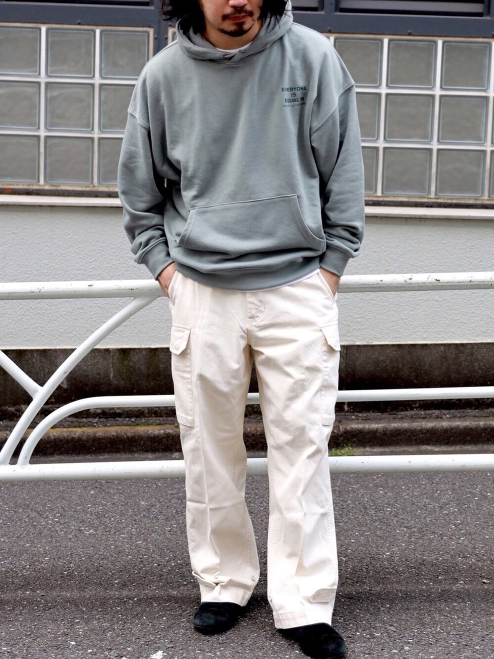 グリーン系のパーカー、ベージュ系のカーゴパンツを着用したメンズの秋コーディネートの1枚目の写真