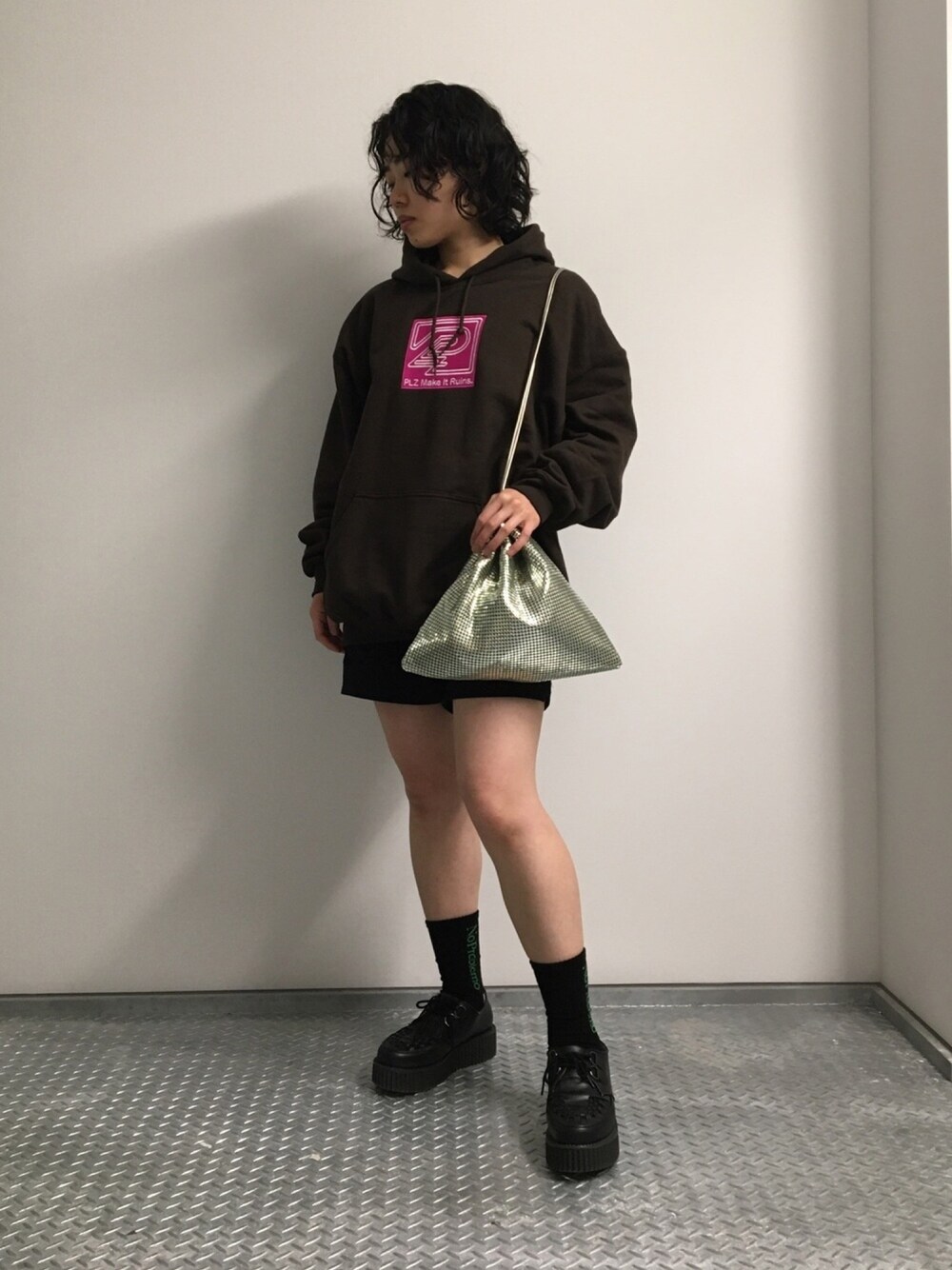 ブラウン系のパーカー、ゴールド系のショルダーバッグを着用したレディースの春コーディネートの1枚目の写真