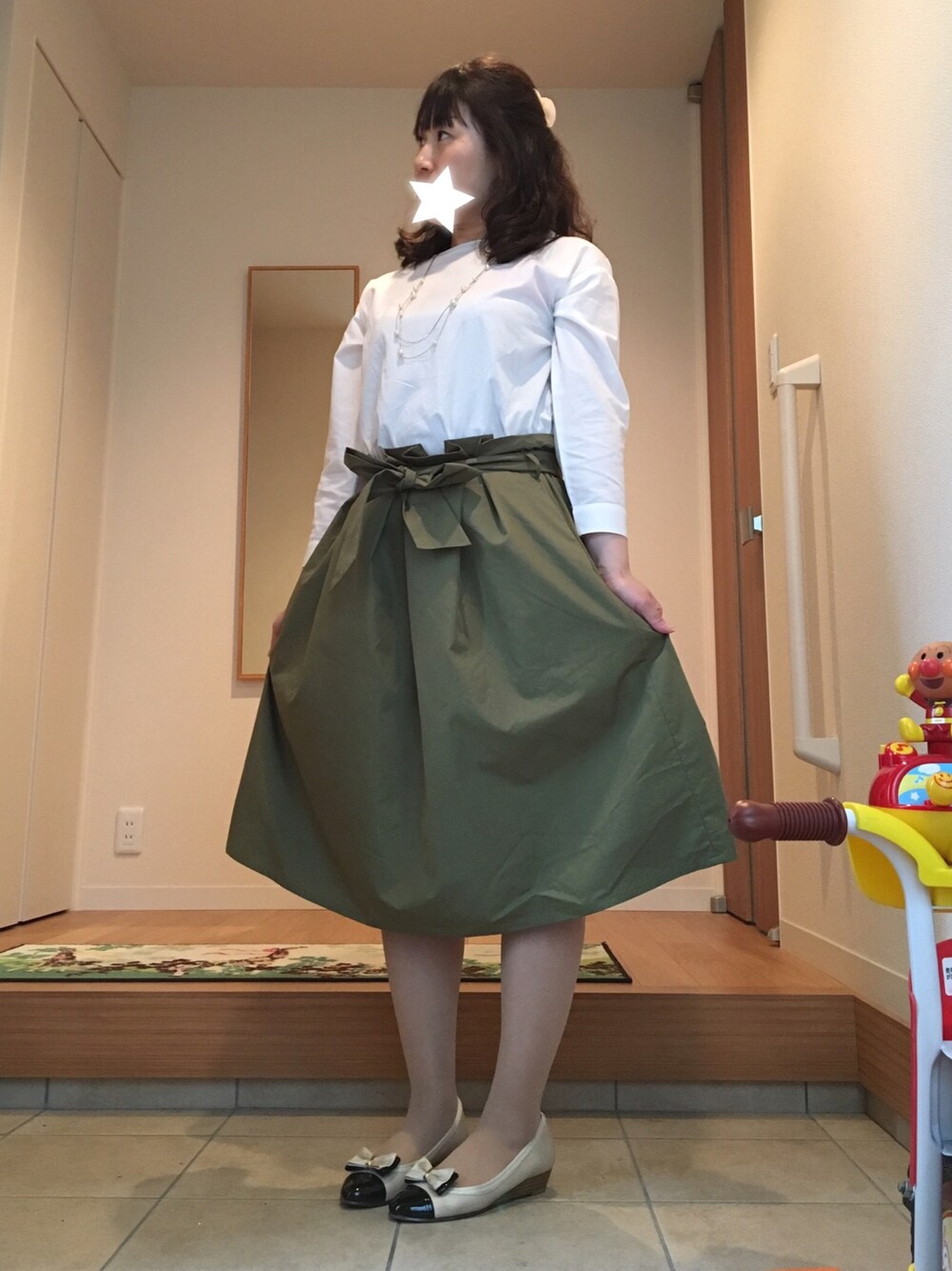 ホワイト系のシャツ/ブラウス、グリーン系のスカート、ベージュ系のパンプスを着用したレディースの春コーディネートの1枚目の写真