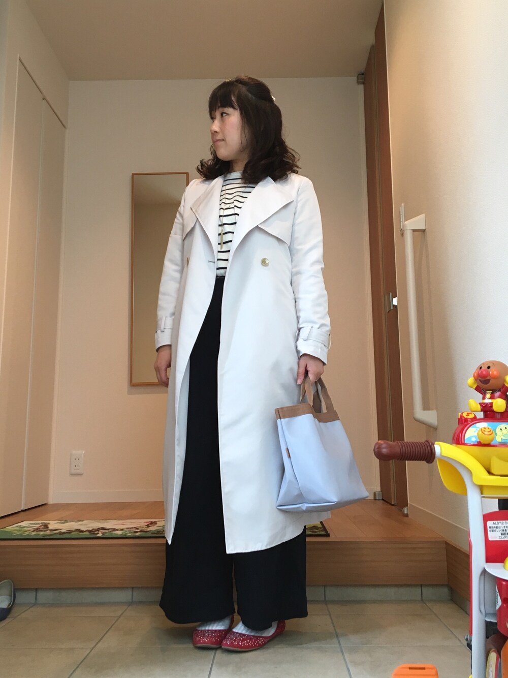 グレー系のトレンチコート、その他のニット/セーター、ブルー系のその他パンツを着用したレディースの春コーディネートの1枚目の写真